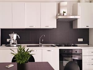 a kitchen with white cabinets and a stove top oven at Casa Margherita in Noci