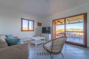 Una sala de estar con un sofá y un televisor. en Mare & Tranquillità - Trilocale con Wi-Fi, en Olbia