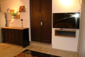 a living room with a large television on a wall at Centro Hannah in Morelia