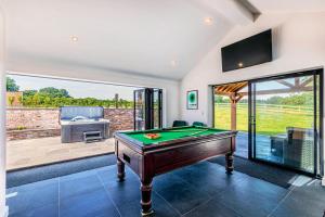 a living room with a pool table and a patio at Fairvale House in Winsford
