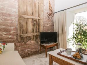 a living room with a wooden wall with a tv at The Roost in Carlisle