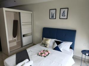 a bedroom with a bed with flowers on it at A-18-09 La Reve SuiteHyveWiFiNETFLIXFreeParking in Cyberjaya +10 photos