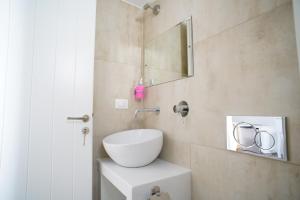 a bathroom with a white sink and a mirror at Casa di Flora in Loutra