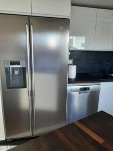 a stainless steel refrigerator in a kitchen at Päikeseline Apartment WITH SAUNA in Kuressaare +14 photos