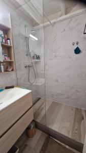 un bagno con doccia con porta in vetro di Chez Michèle a Saint-François