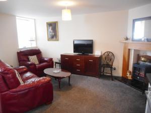 ein Wohnzimmer mit Sofa und Fernseher in der Unterkunft DairyCottage, 5, TELFORD MEWS BEATTOCK in Moffat