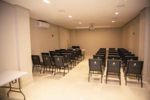 an empty room with chairs and tables in it at Hotel Santa Rita in Santa Cruz