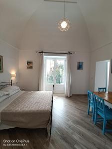a bedroom with a bed and a table and a window at Regina Margherita in Positano