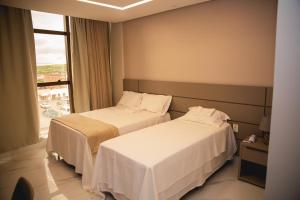 two beds in a hotel room with a window at Hotel Santa Rita in Santa Cruz +77 photos