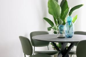 ein Tisch mit Stühlen und zwei Glasflaschen darauf in der Unterkunft Doma Centro 5 in Gela