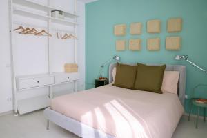 ein Schlafzimmer mit einem Bett und einer blauen Wand in der Unterkunft Doma Centro 5 in Gela