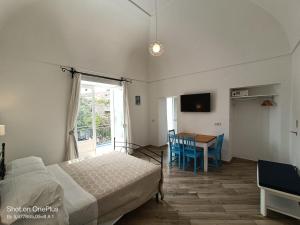a bedroom with a bed and a table and a window at Regina Margherita in Positano