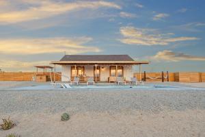 a small white house on the beach with chairs at Loma Vista By The Cohost Company in Sunfair Heights