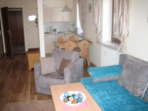 una sala de estar con un sofá y una mesa en Bergschlössl - Eckwohnung 24, en Oberaudorf