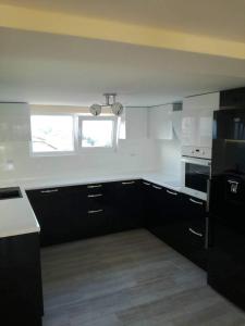 a kitchen with black cabinets and a white counter top at Lux Maisonette in Chernomorets