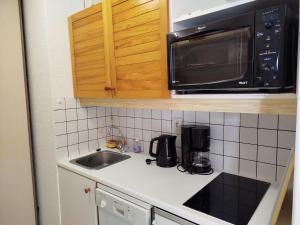 a kitchen with a sink and a microwave at les Dunes in Jullouville-les-Pins +10 photos