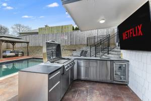 a outdoor kitchen with a grill and a swimming pool at Fun N Sun - Ultimate Backyard Pool And Game Room in Sevierville +45 photos