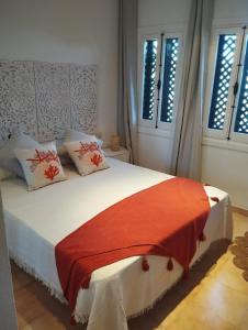 a bedroom with a white bed with a red blanket at azahar playa apartmento in Mazarrón +14 photos