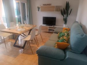 a living room with a blue couch and a table at azahar playa apartmento in Mazarrón