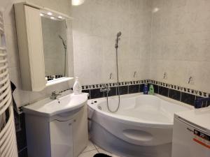 łazienka z wanną, umywalką i toaletą w obiekcie Kiss-Füredi Apartman Szeged w Segedynie +20 zdjęć