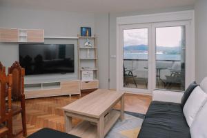 バイヨーナにあるMágicas vistas al mar en Baiona by CABANA Rentalsの大きなテレビとテーブルのあるリビングルーム