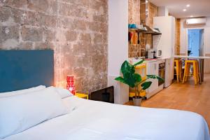 a bedroom with a white bed and a brick wall at Loft independiente con Piscina compartida en Centro de Valencia in Valencia +154 photos