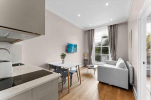 a kitchen and living room with a couch and a table at Grove Heights Notting Hill in London +175 photos