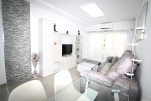 a living room with a couch and a television at Marvelous apartment in Playa del Ingles in Maspalomas