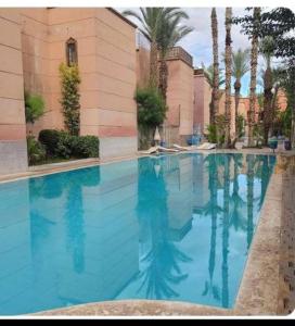 a swimming pool with blue water in front of a building at Bienvenus dans un beau nouveau Riad Tout Entier in Marrakech
