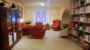 - un salon avec des chaises rouges et des étagères dans l'établissement Chambre d'Hotes La Brunetière, à Gréoux-les-Bains