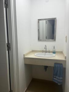 un baño con lavabo y espejo en Edificio Céntrico, en Santiago del Estero