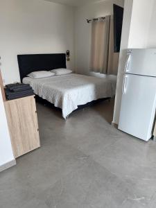 a bedroom with a bed and a white refrigerator at מול ים המלח זוהר במדבר in Neve Zohar