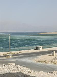 an empty road next to a body of water at מול ים המלח זוהר במדבר in Neve Zohar