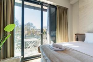 a bedroom with a bed and a large window at Utrecht City Apartments - Huizingalaan in Utrecht