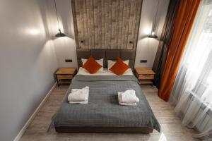 a bedroom with a bed with orange and white pillows at Dream Hotel in Almaty