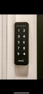a black remote control on a white wall at L Arcade Chic & Confort - Terrasse - 5 min Gare in Amiens +35 photos