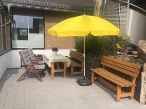 a patio with a table and a yellow umbrella at Rheingau und Weltkulturerbe Mittelrheintal erleben - Ferienappartement in Winkel in Oestrich-Winkel