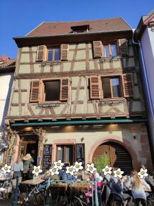 a group of people sitting at tables in front of a building at Au coeur de Kaysersberg-Le Cocon de Jeanne in Kaysersberg