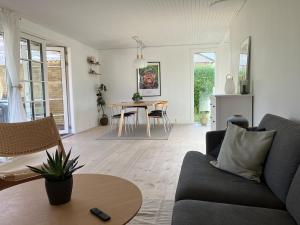 a living room with a couch and a table at House close to city center, beach and Great Northern in Kerteminde