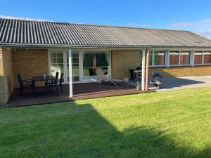 a house with a deck with a table and chairs at House close to city center, beach and Great Northern in Kerteminde