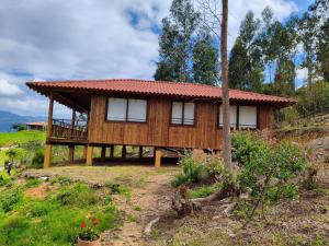 a wooden house with a balcony on a hill at Cabaña Loto - Paipa in Paipa