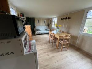 een kleine woonkamer met een tafel en een bank bij Mon chalet dans le Perche in Charbonnières +11 foto's