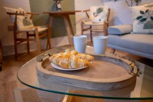 a glass table with a plate of croissants on a table at Corner House Studio in Skipton