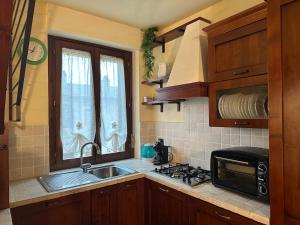 eine Küche mit einer Spüle, einem Herd und einem Fenster in der Unterkunft Boutique House San Filippo in Bagni San Filippo
