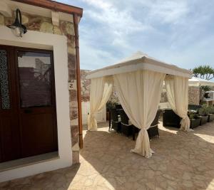 a pavilion with curtains and chairs on a patio at Villa Lucia in Lampedusa