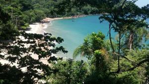 a view of a beach with a boat in the water at Morada Vitória in Ubatuba