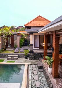 a house with a swimming pool in front of a house at Villa Mulia - 2BR Canggu Bali in Dalung
