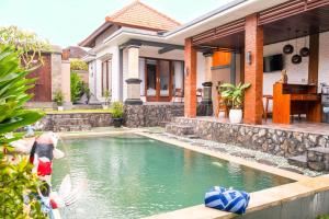 a swimming pool in front of a house at Villa Mulia - 2BR Canggu Bali in Dalung