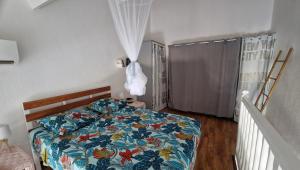 una camera da letto con un letto con un piumone colorato di Chez Michèle a Saint-François Altre 21 foto