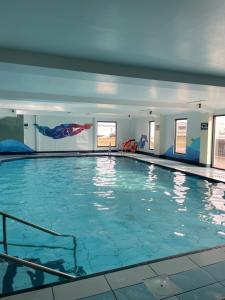a swimming pool with blue water in a building at Ballies Retreat in Lossiemouth